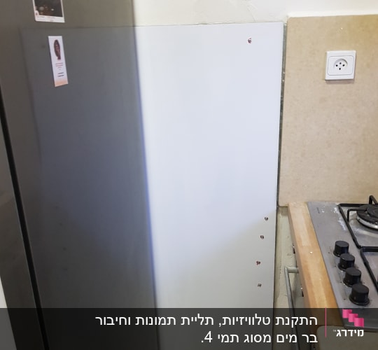 קיר עם לוח מתכת וברגים ליד כיריים